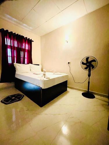 a bedroom with a bed and a fan in it at Runway Residence in Kimbulapitiya