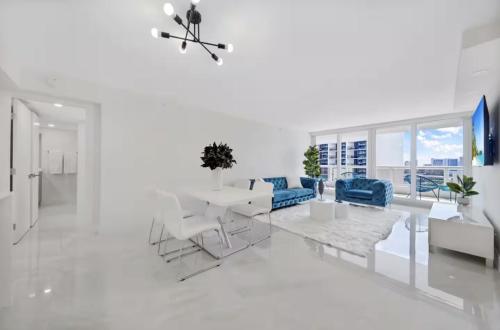 a white living room with a table and chairs at The Grand Biscayne Bay in Miami