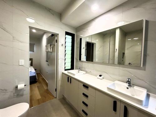 a bathroom with two sinks and a large mirror at Harper in Mission Beach