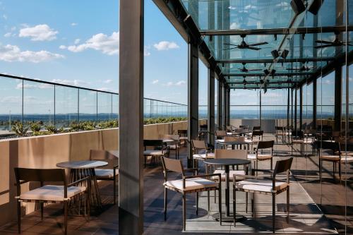 a restaurant with tables and chairs on a balcony at Mercure Melbourne Doncaster in Doncaster