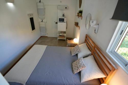 a small bedroom with a bed and a window at Rock’s Beach Spot Suit in Costa da Caparica