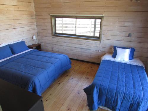 a bedroom with two beds and a window at La madriguera Matanzas in Navidad