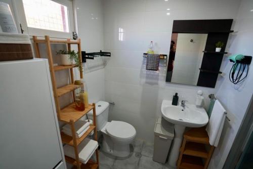 a small bathroom with a toilet and a sink at Rock’s Beach Spot Suit in Costa da Caparica