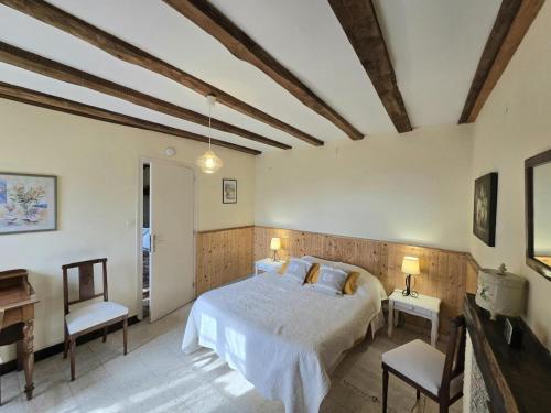 a bedroom with a bed and two chairs and a piano at Charmante maison nature avec parking et animaux acceptés - FR-1-616-459 in Pézuls