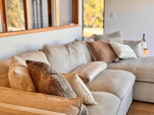 a couch with pillows on it in a living room at Luxe Scandinavian 2BR Retreat Near McLaren Vale in Clarendon