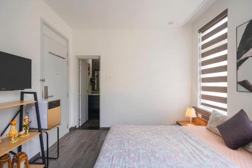 a bedroom with a bed and a large window at La Cle' Đà Lạt in Da Lat