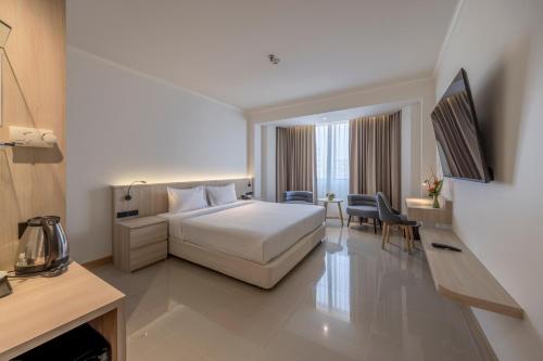 a hotel room with a bed and a desk at The Maruay Garden Hotel in Bangkok