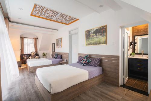 a hotel room with two beds and a sink at La Cle' Đà Lạt in Da Lat