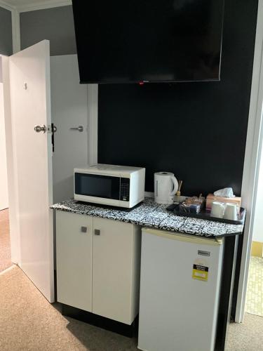 een keuken met een aanrecht met daarop een magnetron bij Commercial Hotel Werris Creek in Werris Creek