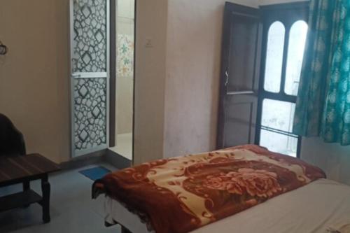 a bedroom with a bed and a window at Yellowoaks Guest House in Baijnāth