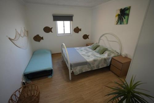 une petite chambre avec un lit et une fenêtre dans l'établissement Rock's Beach Spot A, à Costa da Caparica