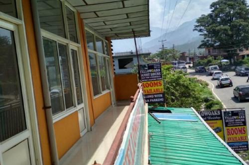 a balcony of a building with signs on it at Yellowoaks Guest House in Baijnāth