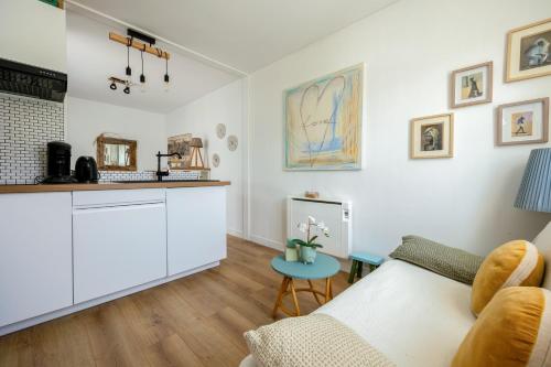 un salon avec un canapé et une table dans l'établissement Cosy courtyard apartment within 15min walk from old town, à La Rochelle