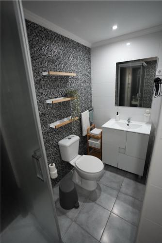 a bathroom with a toilet and a sink at Rock's Beach Spot A in Costa da Caparica