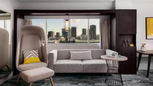 a living room with a couch and a window at voco Brisbane City Centre by IHG in Brisbane