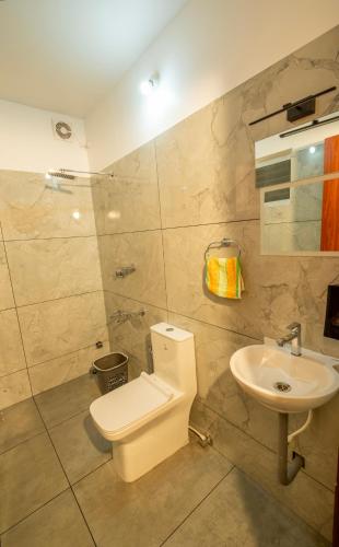 a bathroom with a toilet and a sink at Hotel Eden Palace in Trichūr