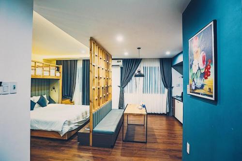 a bedroom with a bed and a desk in a room at The G Hotel Hue in Hue