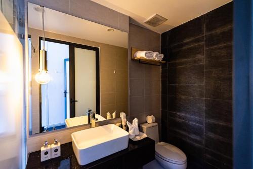 a bathroom with a sink and a toilet and a mirror at The G Hotel Hue in Hue