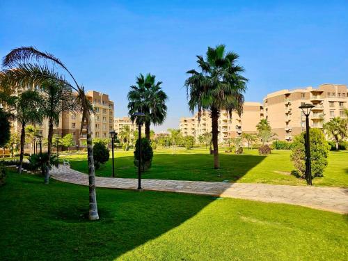 einen Park mit Palmen vor einem Gebäude in der Unterkunft Diamond Madinaty New Cairo in Madinaty
