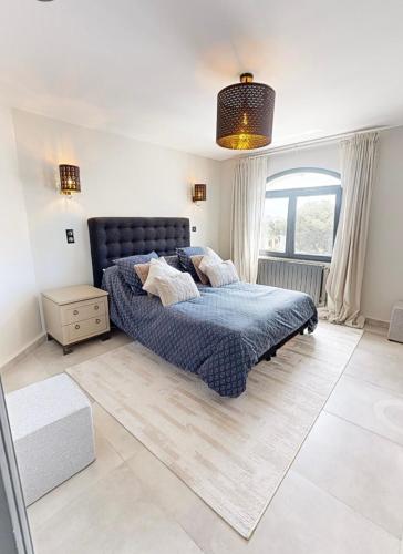 une chambre avec un lit bleu et une fenêtre dans l'établissement Villa aux calanques de Figuerolle, à La Ciotat