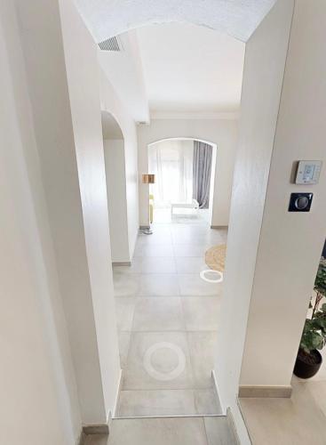 - un couloir dans une maison dotée de murs blancs et de carrelage dans l'établissement Villa aux calanques de Figuerolle, à La Ciotat