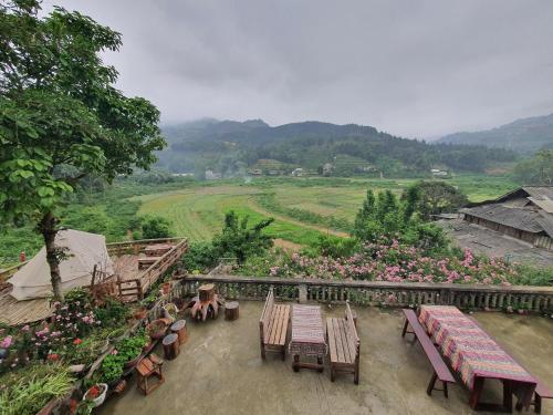 a patio with tables and chairs and a view of a field at La Beauté Bắc Hà in Bắc Hà