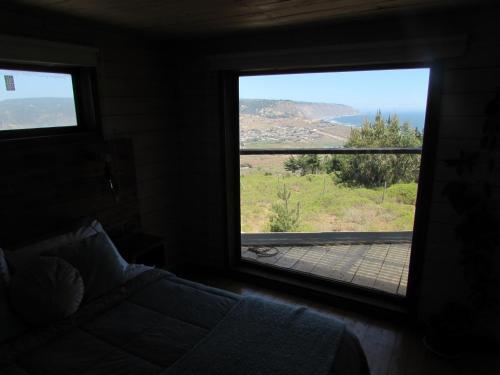 a bedroom with a bed and a window with a view at La madriguera Matanzas in Navidad