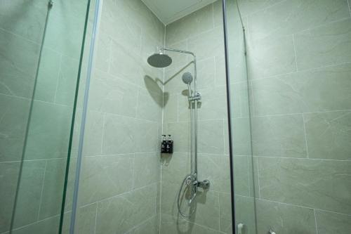 a shower with a glass door in a bathroom at VinaEcolife Lodge in Ba Tri