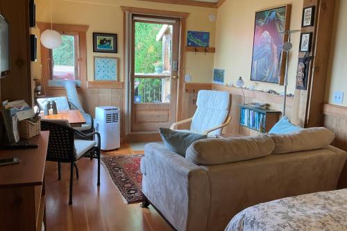 un soggiorno con un divano, un tavolo e delle sedie di Blitz Beach House Oceanside Suite a Powell River