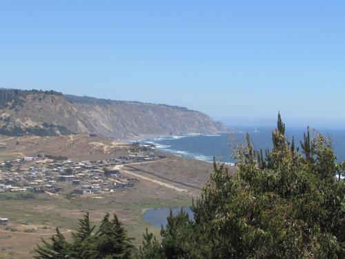 a view of a town and the ocean from a hill at La madriguera Matanzas in Navidad