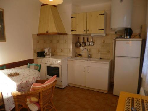 une cuisine avec un réfrigérateur blanc et une table dans l'établissement T3 pour 4 avec Parking à Balaruc-les-Bains - FR-1-571-66, à Balaruc-les-Bains
