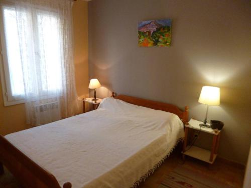 une chambre avec un lit avec deux lampes et une fenêtre dans l'établissement T3 pour 4 avec Parking à Balaruc-les-Bains - FR-1-571-66, à Balaruc-les-Bains