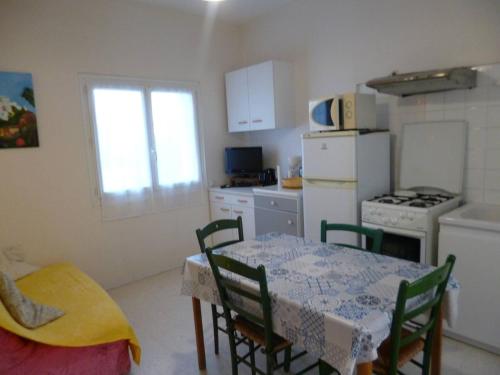 Il comprend une cuisine équipée d'une table, de chaises et d'un réfrigérateur. dans l'établissement T2 Confort avec Parking Proche Centre-ville - FR-1-571-70, à Balaruc-les-Bains