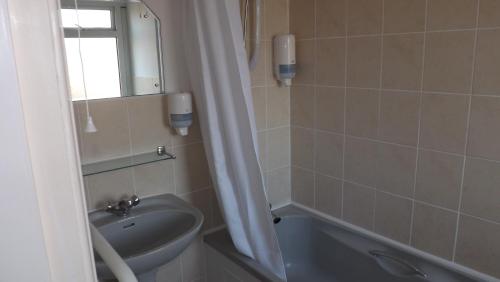 a bathroom with a sink and a toilet and a mirror at Seawold Guest House in St. Brelade