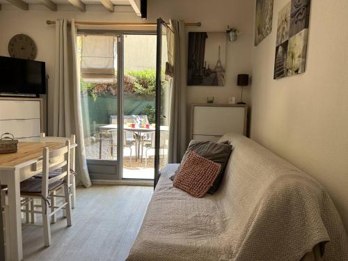 a living room with a bed and a table and a dining room at Mazet climatisé 3 pièces avec piscine et parking, quartier calme, Le Lavandou - FR-1-251-840 in Le Lavandou