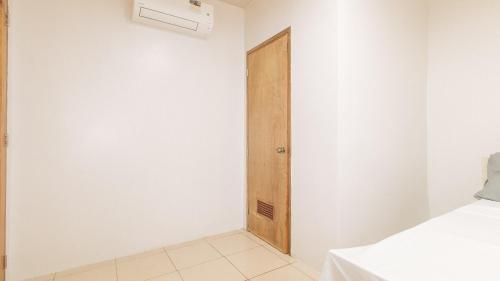 a room with a door and a white wall at Cozy Cove Inn by RedDoorz in Bacolod