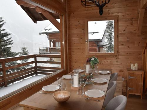 une salle à manger en bois avec une table et un balcon dans l'établissement Chalet cosy à Montgenèvre avec cheminée et WIFI - FR-1-266-244, à Montgenèvre
