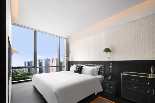 a bedroom with a white bed and a large window at 重庆Indition英迪逊酒店江北嘴金融城店 in Chongqing