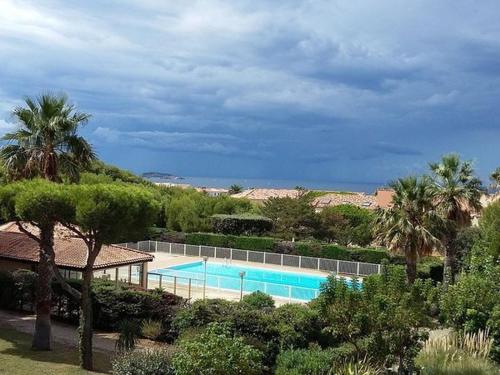 - une piscine dans un complexe avec des palmiers dans l'établissement T2 avec Parking Sécurisé, à 300 m de la Plage, Climatisation Mobile - FR-1-316-343, à Six-Fours-les-Plages