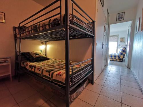 une chambre avec deux lits superposés dans une pièce dans l'établissement Studio cabine pour 4 pers. avec climatisation et parking, vue mer - FR-1-803-74, au Lavandou