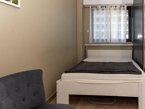 une petite chambre avec un lit et une chaise dans l'établissement T2 au Lavandou face à la mer pour 4 personnes - FR-1-803-80, au Lavandou