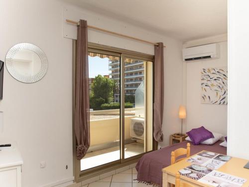 - une chambre avec une porte coulissante en verre donnant sur un balcon dans l'établissement Studio cabine 4 pers, terrasse vue mer, parking, clim - FR-1-803-71, au Lavandou