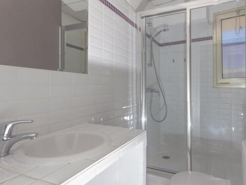 une salle de bain blanche avec une douche et un lavabo dans l'établissement Studio cabine 4 pers, terrasse vue mer, parking, clim - FR-1-803-71, au Lavandou
