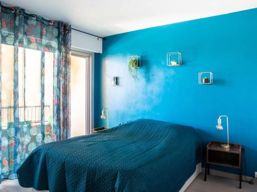 une chambre bleue avec un lit et une fenêtre dans l'établissement T2 climatisé au Lavandou avec WiFi et parking - 4 pers - FR-1-803-77, au Lavandou