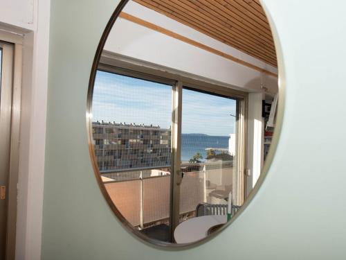 d'un miroir reflétant une chambre avec vue sur un balcon. dans l'établissement Studio avec terrasse, centre ville, climatisation, parking - FR-1-803-86, au Lavandou