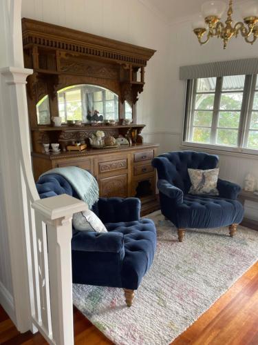 a living room with two blue chairs and a mirror at Emirau in Montville