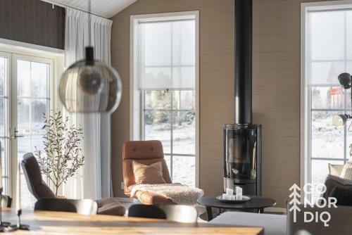 a living room with a couch and a chair and windows at The Red Fox Lodge in Tällberg