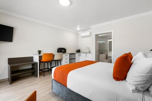 a bedroom with a bed and a desk and a kitchen at Stay 280 & Stay 284 Rotorua - Refurbished Modern Accommodation in Rotorua