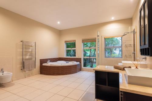 a large bathroom with a tub and a sink at The Hideaway at 88 in Ballito