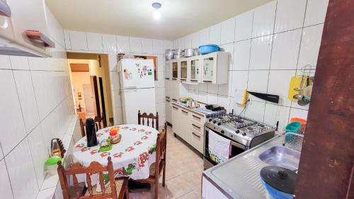 a small kitchen with a table and a refrigerator at Hospedagem Casa Da Lia in Lençóis